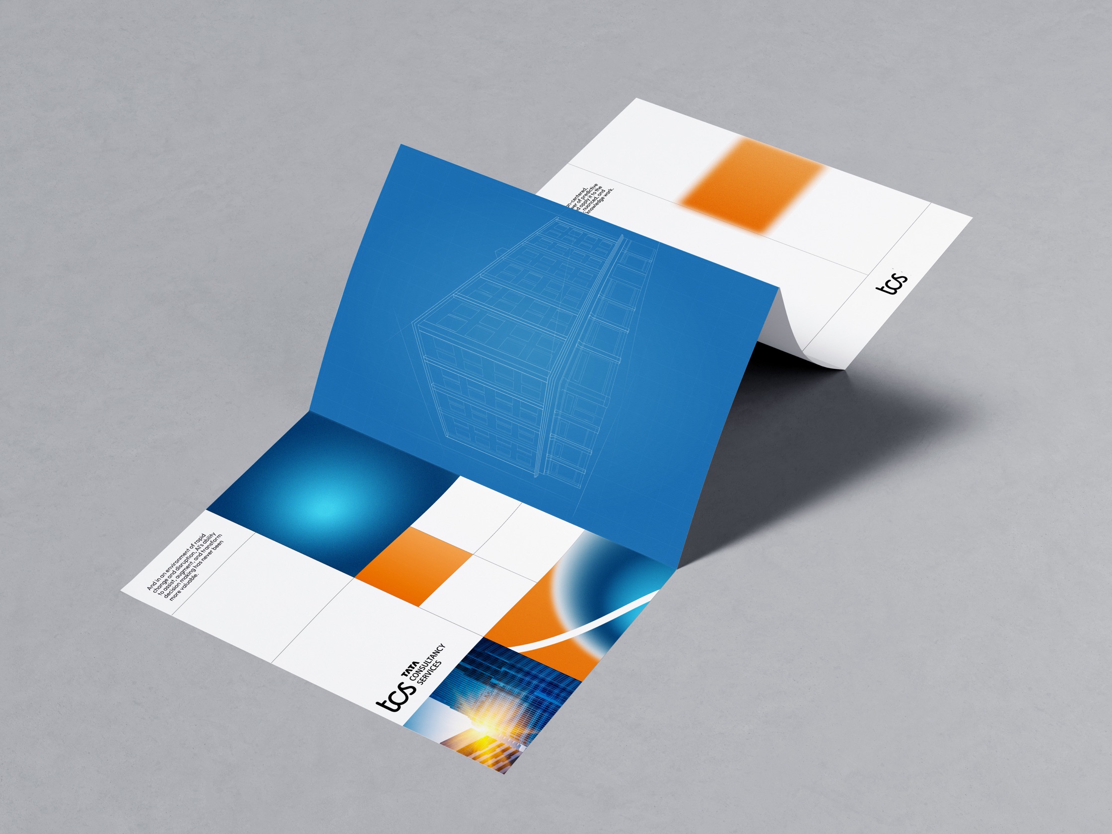 A folded blue leaflet standing open on a grey surface, its gradient panels accented in orange.